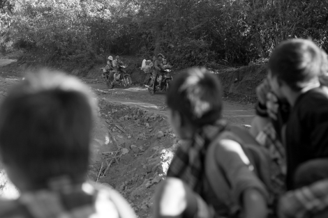 The fleeing Kachin IDPs bumping along a cliffside dirt road in the back of a rickety truck. (Photo © Lee Yu Kyung 2013)